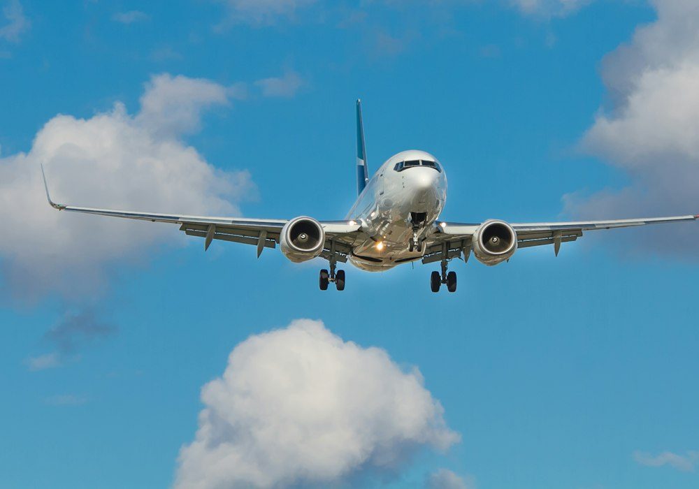 Un avion de ligne en approche sous un ciel tropical lumineux